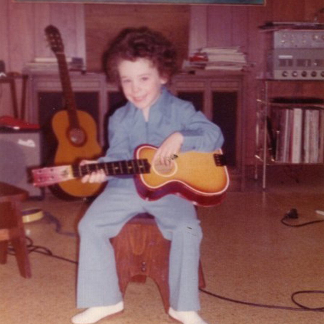 Young Rob Johnston with an acoustic guitar